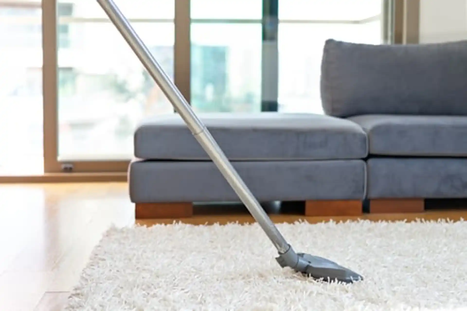Vacuuming a plush white rug in a bright, freshly cleaned Castle Pines living room